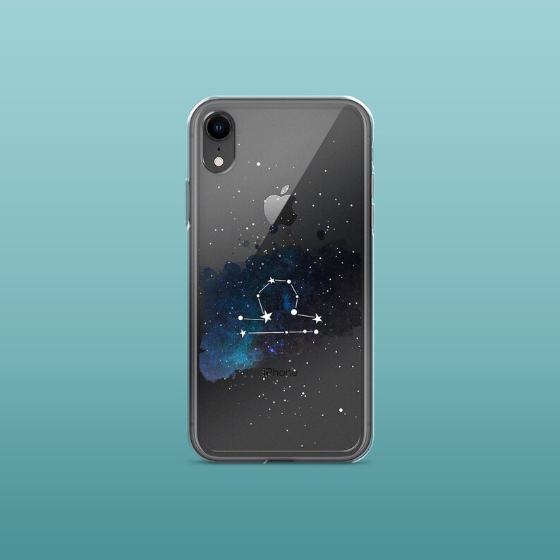 Peut inclure: Coque de t&eacute;l&eacute;phone transparente avec un motif de galaxie noire et un graphique de constellation du zodiaque de la Balance blanche. La coque a une bordure noire et le texte "iPhone" est imprim&eacute; en bas.