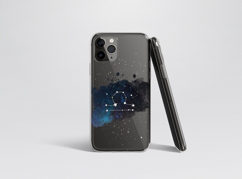 Peut inclure: Une coque de t&eacute;l&eacute;phone transparente avec un fond noir et un motif de constellation de la Balance blanche. La constellation est plac&eacute;e sur un fond de galaxie de style aquarelle bleu et noir.