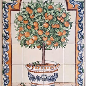 Op de afbeelding: Handgeschilderd keramisch tegelpaneel met een sinaasappelboom in een decoratieve pot. De boom is beladen met rijpe sinaasappels en groene bladeren. De rand heeft een oranje en blauw scrollontwerp. Het kunstwerk staat op een raster van vierkante tegels.