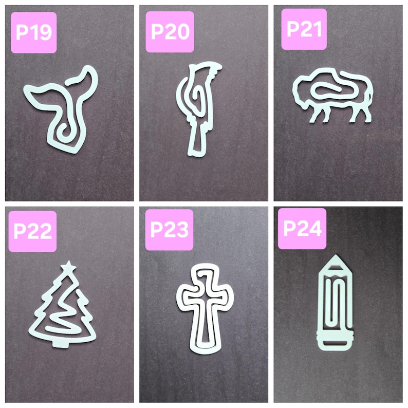 May include: Six white paper clips shaped like different objects: a whale, a cardinal, a bison, a Christmas tree, a cross, and a pencil. Each clip has a pink label with a number and letter, such as "P19" or "P24".