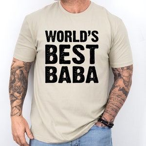 May include: A beige t-shirt with the text "WORLD'S BEST BABA" printed in black.
