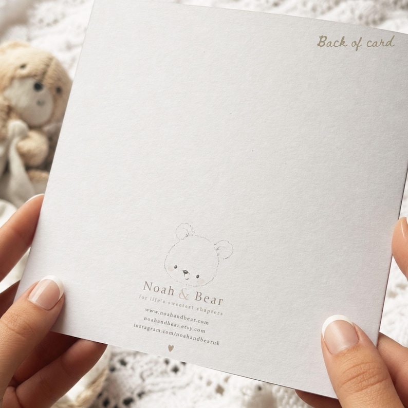 May include: A square white card featuring the text Back of card in the top right corner. The center bottom displays a small bear illustration with the text Noah & Bear, for life's sweetest chapters, and website and social media links.