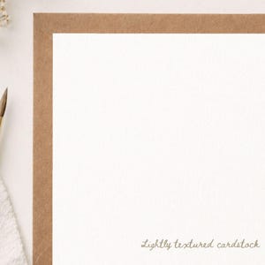 Puede incluir: Una pieza rectangular de cartulina blanca con una textura sutil, enmarcada por un borde marr&oacute;n. El texto "Lightly textured cardstock" est&aacute; impreso en una fuente cursiva marr&oacute;n en la esquina inferior derecha del &aacute;rea blanca de la cartulina.