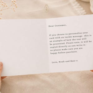 Puede incluir: Una tarjeta de felicitaci&oacute;n blanca con texto impreso en negro en el lado derecho que dice: Dear Customer, If you choose to personalise your card with an inside message- this is an example of how the text will be presented. Love, Noah and Bear x.