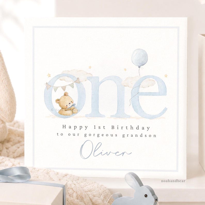 Puede incluir: Una tarjeta de felicitaci&oacute;n cuadrada con la palabra one en letras grandes de color azul claro. Un peque&ntilde;o oso de peluche marr&oacute;n se sienta dentro de la letra o, junto a nubes, estrellas y un globo azul. El texto dice Happy 1st Birthday to our gorgeous grandson Oliver.