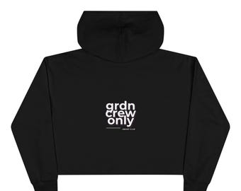 Puede incluir: Sudadera con capucha corta negra con capucha y mangas largas. El texto "grdn crew only" está impreso en blanco en la parte posterior. Debajo del texto está la frase "smoke club".
