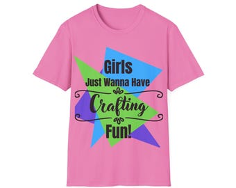 May include: Pink t-shirt with the text "Girls Just Wanna Have Crafting Fun!" in black script and a colorful geometric design. The shirt is a short-sleeved crew neck.