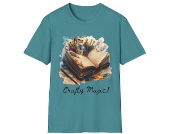 May include: Teal t-shirt featuring a watercolor illustration of an open book surrounded by art supplies. The image includes pencils, paintbrushes, and small photos. The text "Crafty Magic!" is written below the illustration.