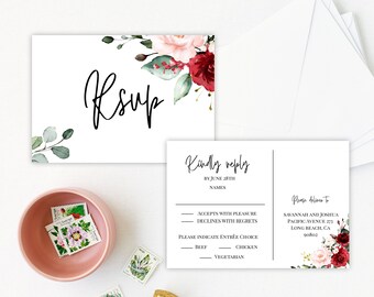May include: RSVP card with floral design. The card has a white background with a floral design in shades of red, pink, and green. The text "RSVP" is written in black cursive font. The card also includes a section for guests to indicate their attendance and meal choice.