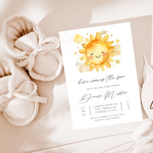May include: A baby shower invitation with a watercolor illustration of a smiling sun with clouds and stars. The text reads "here comes the son" and includes the details of the event, including the date, time, location, and RSVP information.