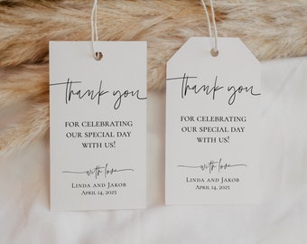 May include: Two white thank you tags with black calligraphy. The text reads "Thank you for celebrating our special day with us! With love, Linda and Jakob, April 14, 2025".