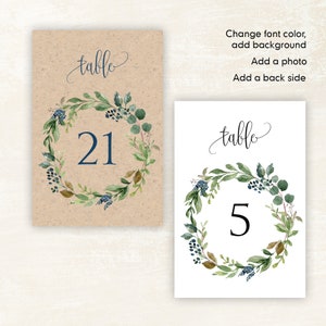 May include: Two table number cards with a watercolor wreath design. The first card has a brown background and the number 21. The second card has a white background and the number 5. Both cards have the text "table" in cursive.