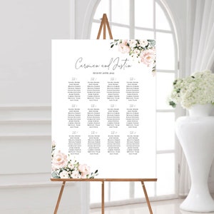Puede incluir: Un plano de asientos de boda con un dise&ntilde;o floral con flores rosas y blancas. El plano est&aacute; titulado "Carmen y Justin" y enumera los nombres de los invitados asignados a diferentes mesas.