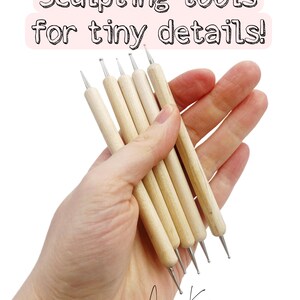 Könnte beinhalten: Nahaufnahme von einer Hand, die ein Set von Modellierwerkzeugen mit Holzgriffen und Metallspitzen hält. Der Text "Sculpting tools for tiny details!" ist zu sehen. Die Signatur des Künstlers, "Anna Karp", ist unten.