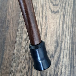 Puede incluir: Un bast&oacute;n de madera marr&oacute;n con una punta de goma negra.