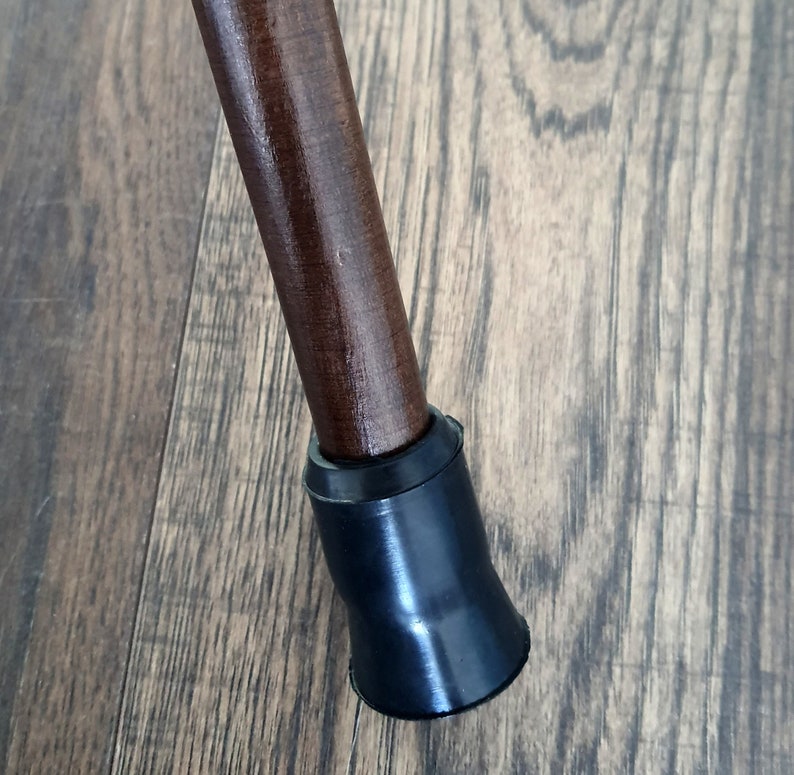 Puede incluir: Un bast&oacute;n de madera marr&oacute;n con una punta de goma negra.