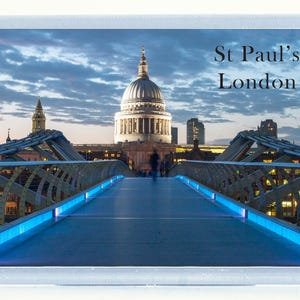 Puede incluir: Un imán rectangular con una fotografía de la Catedral de San Pablo en Londres al anochecer. La imagen incluye el Puente del Milenio con luces azules y el texto "St Paul's London".