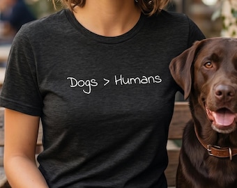 Maglietta premium in tessuto tri-blend "Cani > Umani" / Maglietta divertente per amanti dei cani / Maglietta per genitori e mamme di cani introversi (colori scuri)