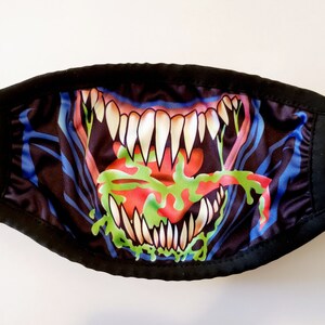 May include: Black face mask with a colorful graphic of a monster's open mouth with sharp teeth and a green tongue.