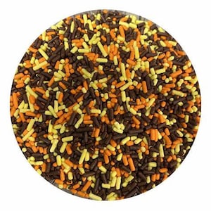 May include: A circular arrangement of colorful sprinkles in shades of brown, orange, and yellow. The sprinkles are small, cylindrical shapes, creating a textured, appetizing appearance. Ideal for decorating baked goods.