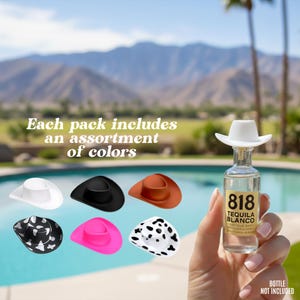 May include: Miniature cowboy hat bottle stoppers in white, black, brown, pink, and patterned designs. The image includes a bottle of tequila with a white cowboy hat stopper. Text reads: "Each pack includes an assortment of colors."