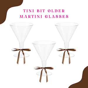 Puede incluir: Tres copas de martini de vidrio transparente con lazos de cinta marrón. Las copas están vacías y tienen un aspecto vintage. El texto "TINI BIT OLDER MARTINI GLASSES" está en la parte superior de la imagen.