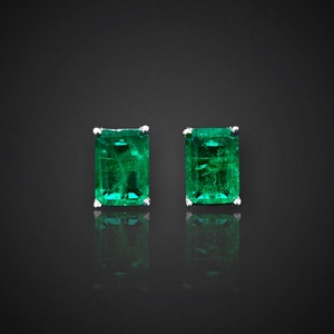 Puede incluir: Un par de pendientes de esmeralda verde engastados en plata.