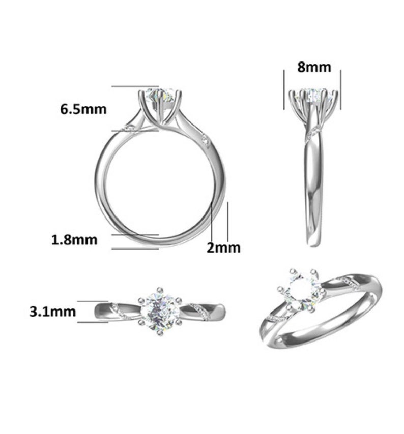 May include: A silver ring with a round, clear gemstone in the center. The ring is 6.5 mm wide and 2 mm thick. The gemstone is 8 mm in diameter.