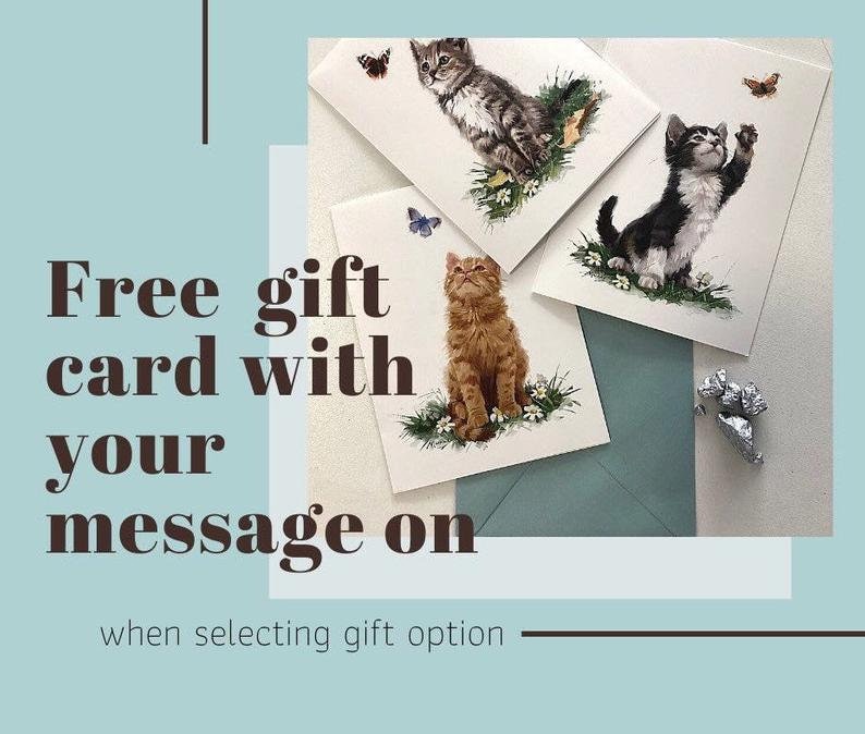 May include: Four greeting cards with cat illustrations, each featuring a different kitten pose. The cards are on a white surface, with a teal envelope and text that reads "Free gift card with your message on when selecting gift option."