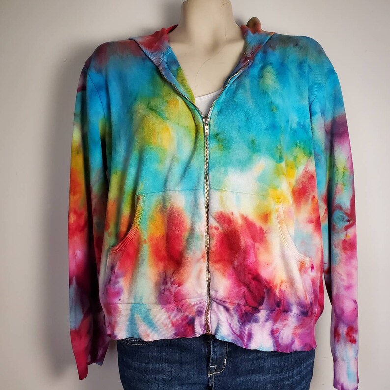 May include: A tie-dye zip-up hoodie with a colorful swirl pattern in shades of blue, yellow, red, and purple.