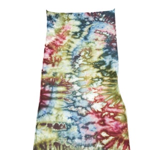 K&ouml;nnte beinhalten: Ein Batikstoff mit einem bunten Wirbelmuster in Blaut&ouml;nen, Gr&uuml;nt&ouml;nen, Rott&ouml;nen und Wei&szlig;.