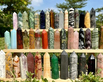 May include: A collection of 36 polished crystal points arranged on a wooden stand. The points are various colors and patterns, including clear, green, red, black, and white.