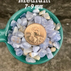 Puede incluir: Una cuchara verde llena de trozos de &aacute;gata azul, que van de 7 a 9 mm. Los trozos son de color azul claro con marcas blancas y marrones. Se incluye una moneda estadounidense Liberty como referencia de tama&ntilde;o.