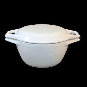 May include: A solid white ceramic casserole dish with a matching lid. The round pot features two integrated side handles that extend outwards from the rim, providing a secure grip. The surface is smooth, glossy, and uniform in colour throughout.