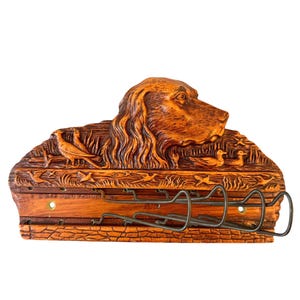 May include: Wooden wall mounted key holder with a carved brown dog and birds. The holder has five metal hooks.