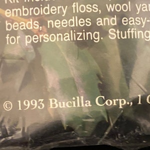 May include: Close-up of a product label with the text "1993 Bucilla Corp., 1 Oak" printed in white on a dark background.