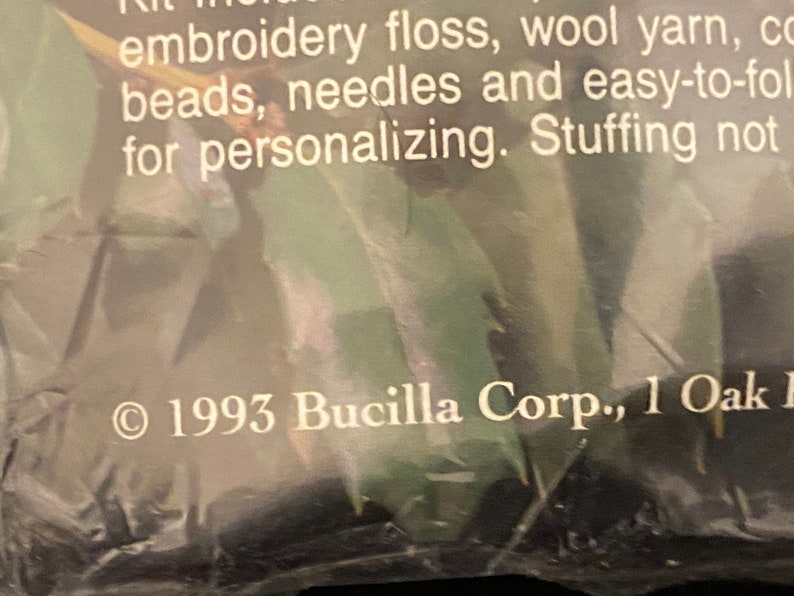 May include: Close-up of a product label with the text "1993 Bucilla Corp., 1 Oak" printed in white on a dark background.