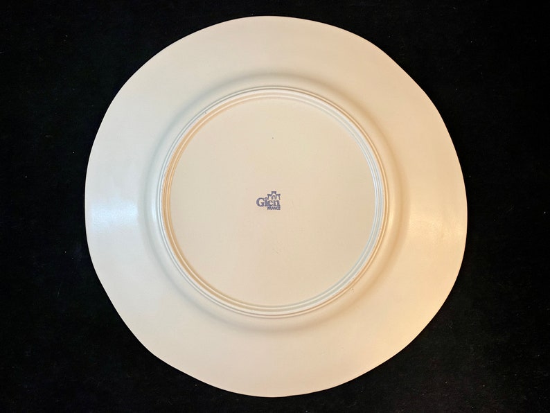 K&ouml;nnte beinhalten: Die R&uuml;ckseite eines wei&szlig;en Keramik-Dinnertellers mit einem blauen "Gien France"-Logo in der Mitte.