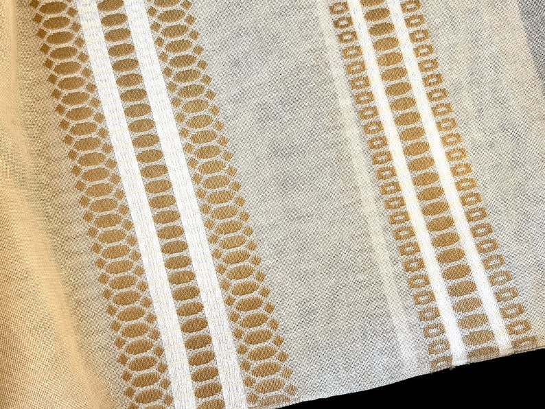 May include: A close-up of a sheer fabric with a repeating pattern of brown and white stripes. The fabric has a subtle sheen and a delicate texture.