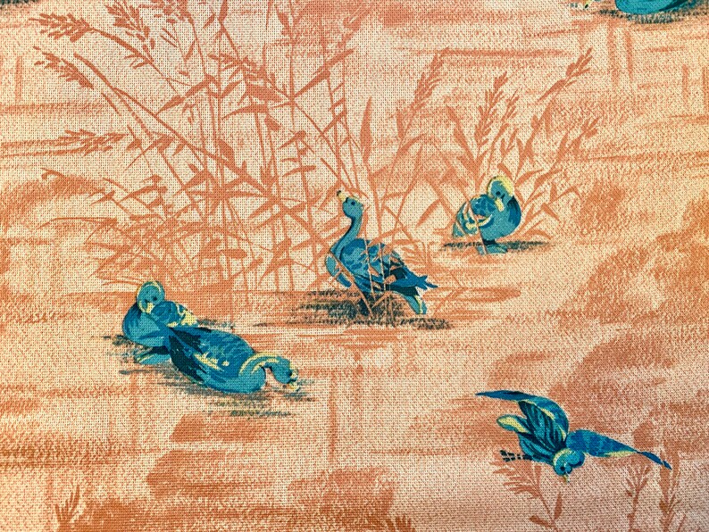 May include: A vintage wallpaper design featuring blue ducks swimming in a pond with brown reeds in the background.
