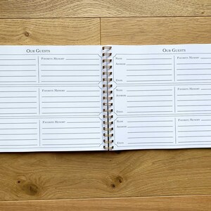 May include: A white guest book with a gold spiral binding. The book has two pages, each with the title "Our Guests" and spaces for names, addresses, emails, and favorite memories.