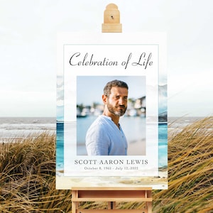 May include: A white poster with a blue watercolour background and a photo of a man. The poster says "Celebration of Life" and "Scott Aaron Lewis, October 8, 1965 - July 12, 2022".