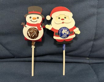 Un par de piruletas navideñas (Santa Claus y Muñeco de Nieve)