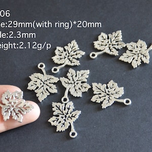 Puede incluir: Ocho abalorios de hoja de metal plateado con un agujero y un bucle a cada lado. Las hojas miden aproximadamente 29 mm de largo y 20 mm de ancho. Los abalorios están etiquetados como CT06, Tamaño: 29 mm (con anillo) * 20 mm, Agujero: 2,3 mm, Peso: 2,12 g/p.