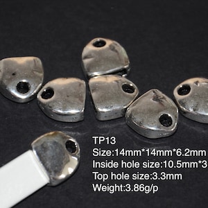 Puede incluir: Encantos de colgante de metal plateado con forma de lágrima y un agujero en la parte superior. Los encantos miden 14 mm x 14 mm x 6,2 mm. El agujero interior mide 10,5 mm x 3,0 mm y el agujero superior mide 3,3 mm. Los encantos pesan 3,86 gramos cada uno.