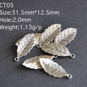 Peut inclure: Cinq breloques en forme de feuille en métal argenté avec une surface texturée. Chaque breloque mesure 31,5 mm sur 12,5 mm et possède un trou de 2,0 mm. CT05