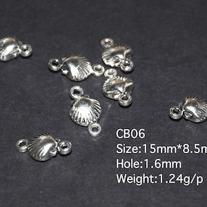 Op de afbeelding: Zilverkleurige metalen schelpvormige connector charms met twee springringen. De charms zijn 15 mm bij 8,5 mm en hebben een gat van 1,6 mm. CB06. Maat: 15 mm * 8,5 mm. Gat: 1,6 mm. Gewicht: 1,24 g/p