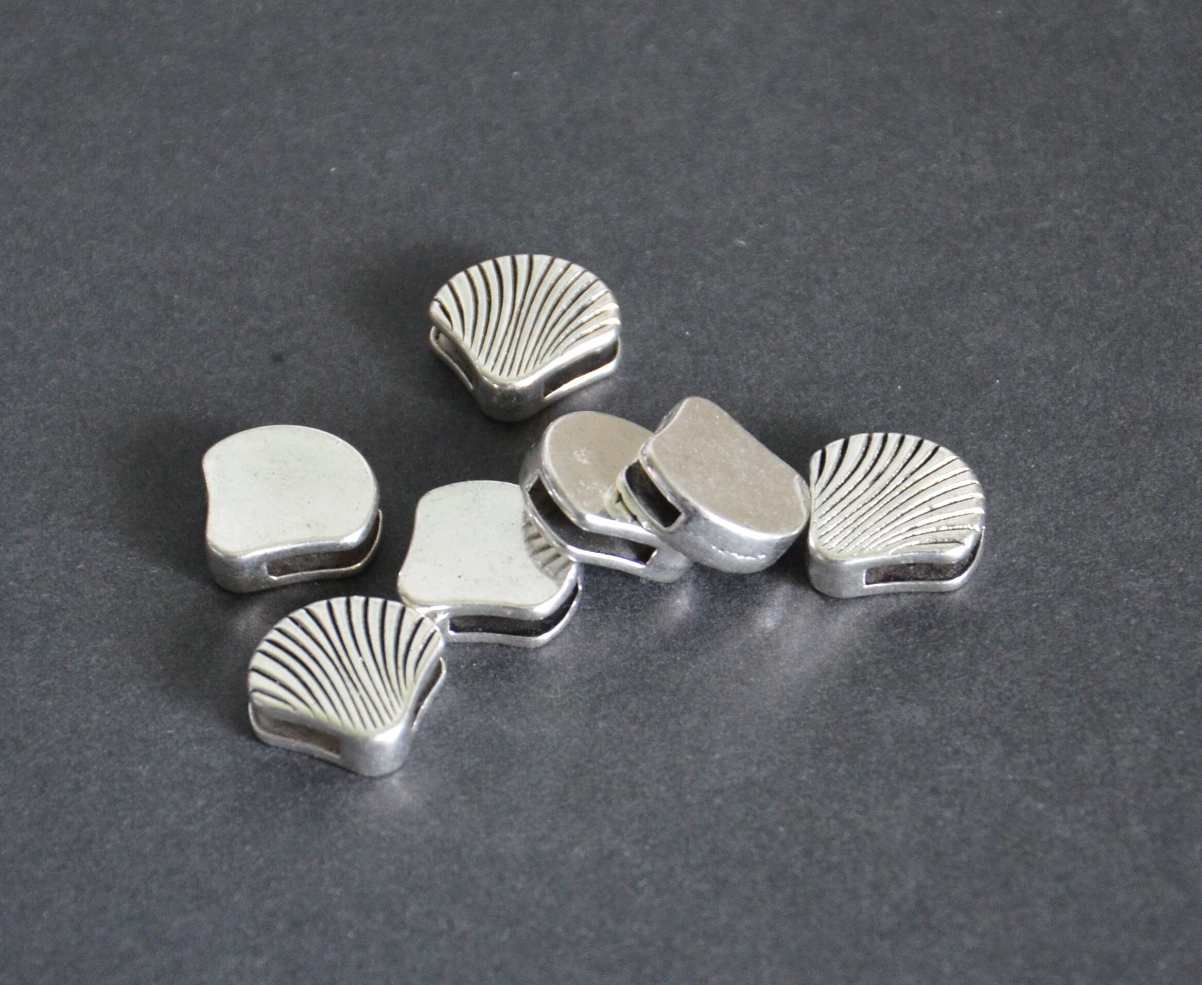 a set of 7 pieces conch symbol alloy beads-silver tone round flat metal beads-flat leather cord beads-conch carving beads-conch shape beads