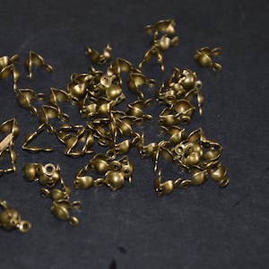 以下が含まれることがあります： ジュエリー作りやその他のクラフトプロジェクトに最適な、金色の金属製の留め具がたくさんあります。
