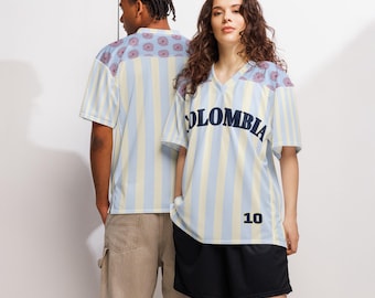May include: Two people wearing light blue and yellow striped jerseys with the word "COLOMBIA" across the chest. The jerseys have a V-neck and the number "10" on the front. The sleeves and shoulders have a floral pattern.